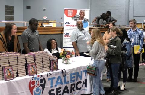 A picture of an author signing a book for a young fan.